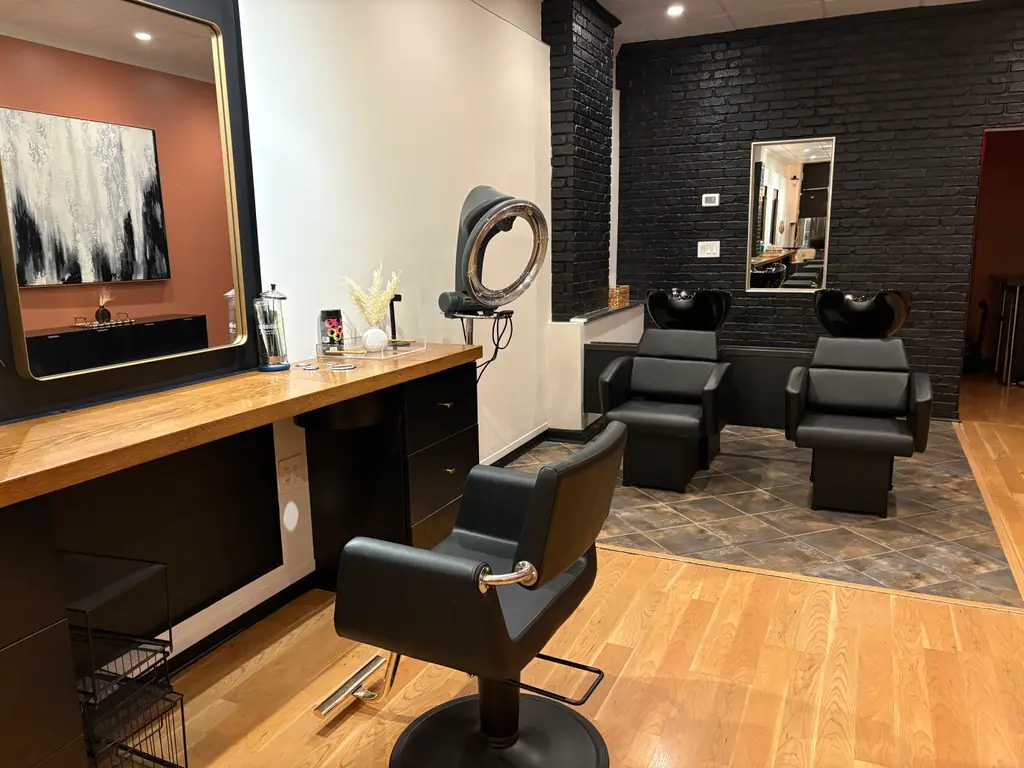 A styling station with blush walls and a black brick feature wall