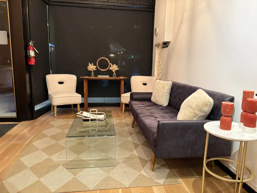The client lounge at Ciao Bella Hair Studio with velvet sofa and gold accents