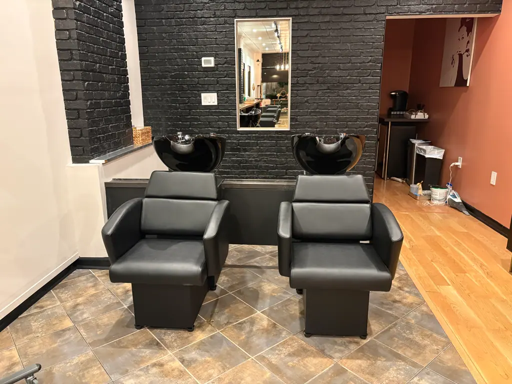 Shampoo stations in front of a black brick wall